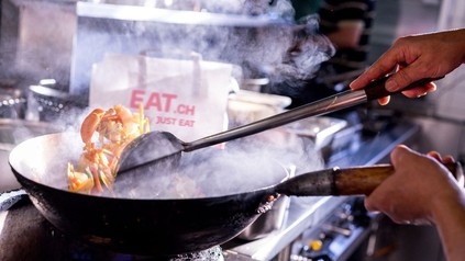 Koch in einem China-Restaurant arbeitet mit einem Wok.