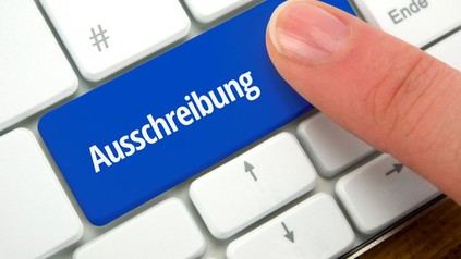 Mann drückt auf Taste Ausschreibung