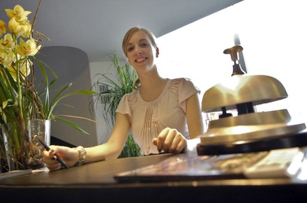 Eine gutgelaunte Empfangskraft an der Rezeption eines Hotels