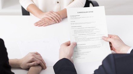 HR-Verantwortlicher hält CV einer Kandidatin in der Hand