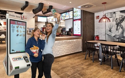 Tipos-Terminal bei einem KFC mit zwei jungen Kundinnen, die ein Selfie schießen