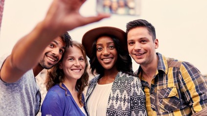 Gruppe fotografiert sich selbst mit Smartphone