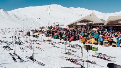Gute besuchte Skihütte auf einer Piste bei Traumwetter