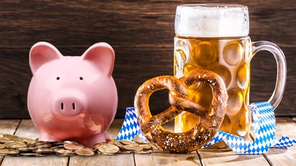 Ein Bier auf einem Tisch und daneben einige Geldmünzen