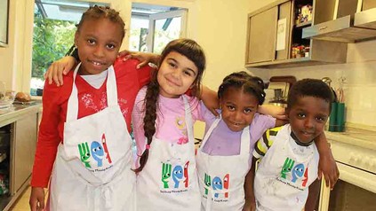 Vier Kinder in Kochschürzen