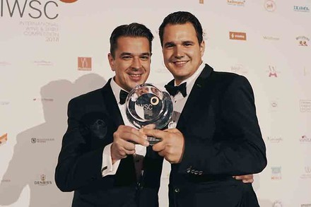 Zwei preisträger mit einem Pokal