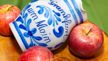 Ein Krug mit Apfelwein und mehrere rote Äpfel