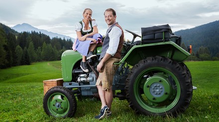Gastgeber Alois Seyrling und seine Frau Agnes auf einem Traktoru
