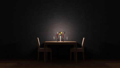 Ein Restauranttisch mit Kerzen und Gläsern im Dunkeln