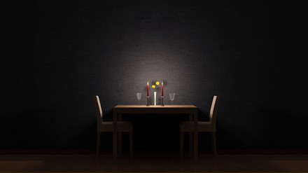 Ein Restauranttisch mit Kerzen und Gläsern im Dunkeln