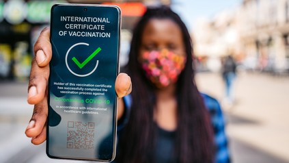 Frau hält Handy mit Impfnachweis in die Kamera