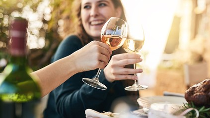 zwei Menschen stoßem mit einem Glas Rosé an