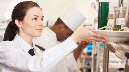 Junge Servicekraft nimmt Essen entgegen