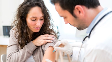 Junge Frau bekommt eine Impfung vom Arzt