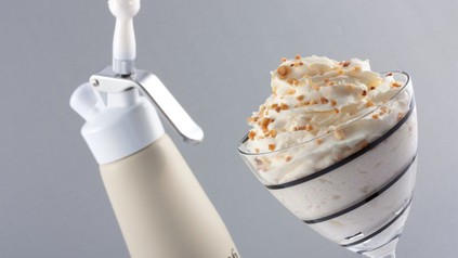 Schlagsahne-Spender und Schlagsahne im Glas