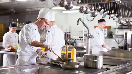 Blick in eine Großküche mit Köchen und Küchenhelfern