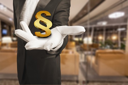 Ein Kellner mit einem Paragrafenzeichen in der Hand