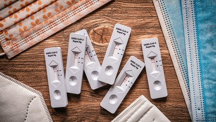 Coronatest umringt von OP-Masken