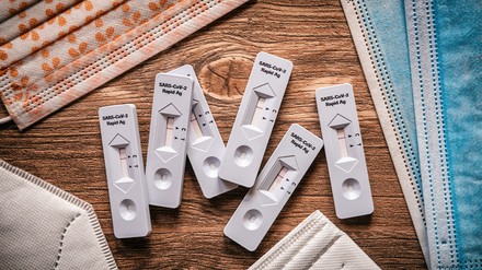 Coronatest umringt von OP-Masken