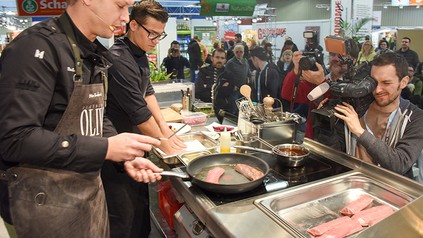 Ein Team von jungen Köchen kocht in einer Messehalle der HOGA-Messe