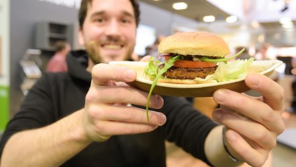 Ein junger Mann mit einem Insektenburger
