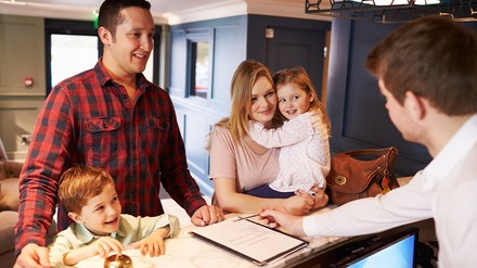 Familie beim Checkin im Hotel