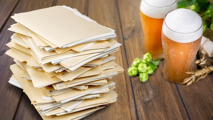 Zwei Bier und ein Stapel Akten auf einem Wirtshaustisch