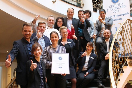 Zahlreiche Vertreter des VILA VITA HOtels auf einer Treppe sitzend