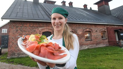 Eine junge Dame in Finnland serviert frischen Lachs.