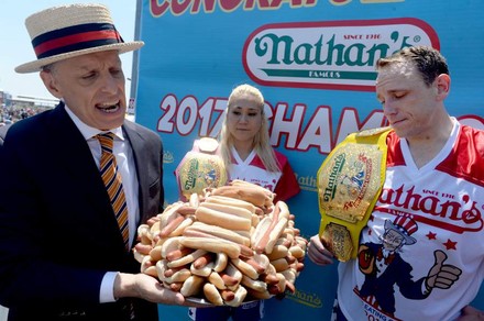 Alter Mann hält Teller voller Hotdogs in Händen