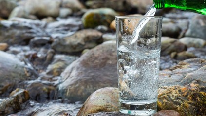 Mineralwasser wird in Glas geschüttet