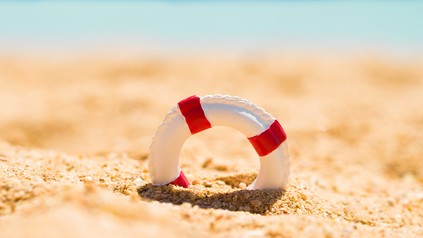 Kleiner Rettungsring als Symbol im Sand