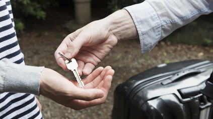 Vermieter übergibt Schlüssel an Touristen