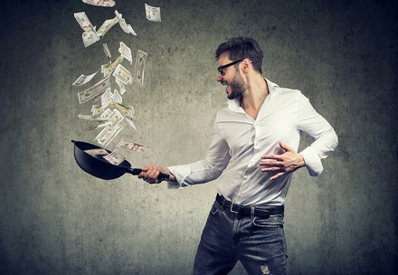 Ein Koch schwenkt eine Pfanne voller Geld