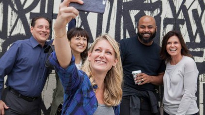Frau schießt Selfie mit mehreren Personen