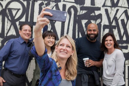Frau schießt Selfie mit mehreren Personen