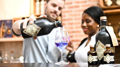 Ein Barkeeper schenkt an einem Messestadt einen ungewöhnlichen Gin aus