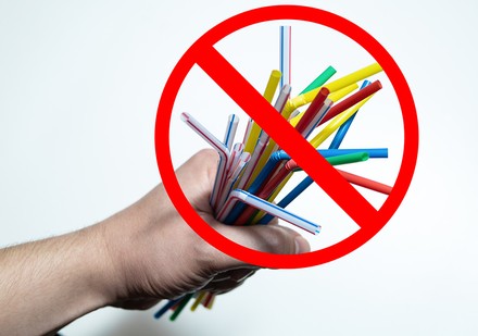 Eine Handvoll Plastikstrohhalme mit einem „Durchgestrichen“-Symbol