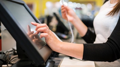 Eine Kellnerin tippt eine Rechnung in ein Kassensystem ein