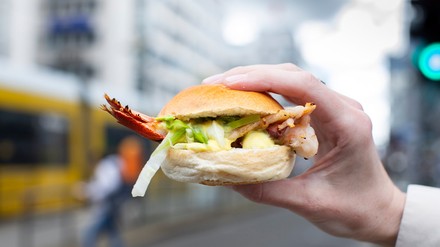 Ein halber Hummerschwanz mit Brioche-Brötchen, Zuckerschoten-Salat, Kokos-Koriander-Vinaigrette und Sauce Rouille.