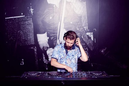 DJ mit Schnurrbart an Turntables