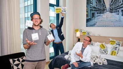 Hipster jongliert mit Klopapier in Hotelzimmer