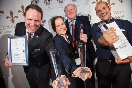 Eine Gruppe glücklicher Gewinner mit Urkunden und Pokalen in der Hand