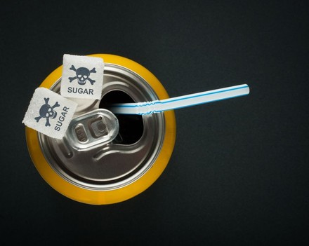 Getränkedose mit Zuckerwürfeln, auf denen Totenköpfe abgebildet sind