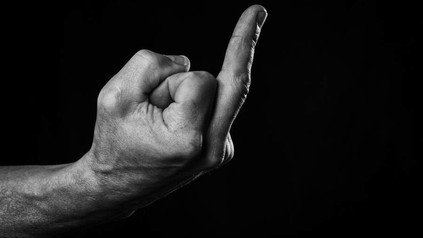 Eine Hand erhebt den Mittelfinger