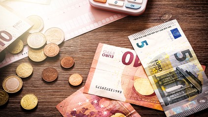 Bargeld und Taschenrechner auf dem Tisch