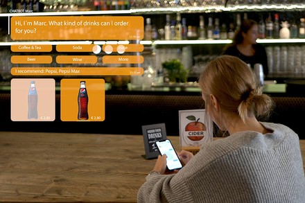 Eine Frau mit einem Handy an einer Bar