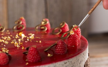 Himbeer-Torte wird mit Blattgold verziert
