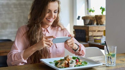 Frau macht Foodporn Bild mit Smartphone