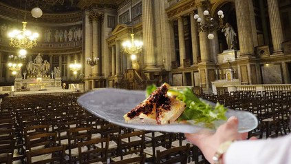 Die Pariser Kirche Madeleine komplett bestuhlt und ein Kellner, der ein Gericht serviert